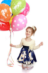 Happy little girl holding a lot of balloons.