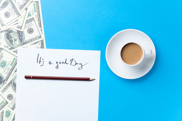 Cup of coffee and paper with inscription and dollars