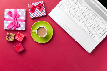 Cup of coffee and gift near computer