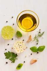 ingrediets for salad dressing. Olive oil, garlic, lemon, herbs a