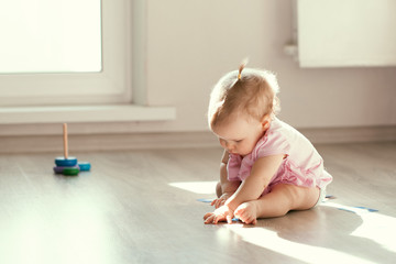 Little girl playing with pyramid on floor