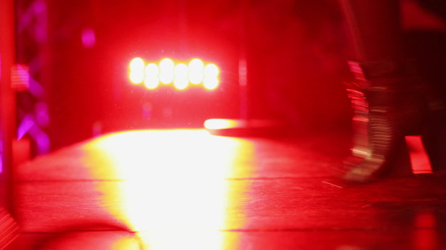 Close-up of Feet with High Heels Jumping on Stage with back light during a Performance