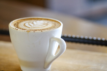 Hot Cappuccino with white cup on wood table coffee house