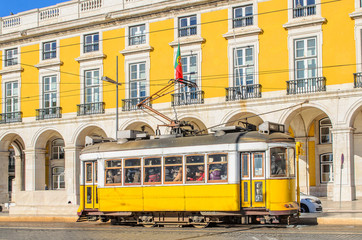Naklejka na ściany i meble Traditional yellow trams on a street in Lisbon, Portugal