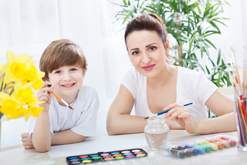 Smiling beautiful family with accessories for drawing