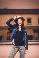 fashion girl in hat and jeans posing in the city