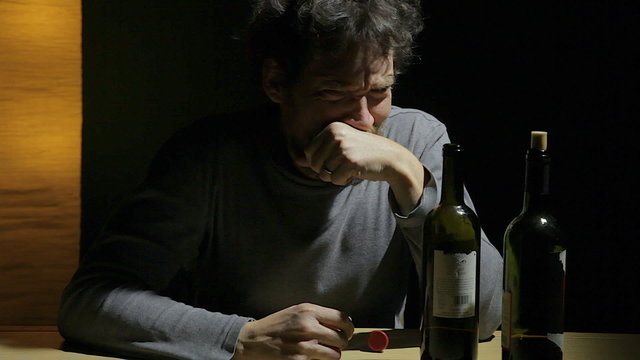 Desperate sad man looking two empty bottle