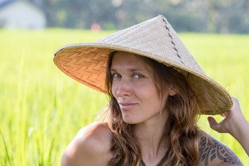 Portrait girl in straw hat against the backdrop of rice field