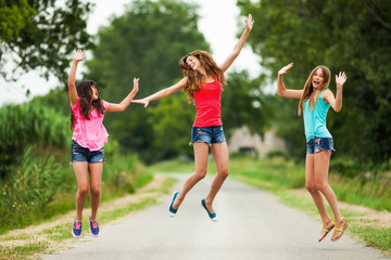 Three happy girls jumping