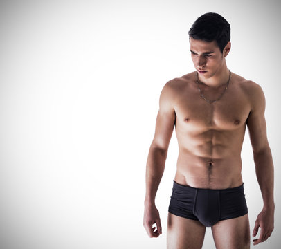 Handsome, fit young man in underwear on white background