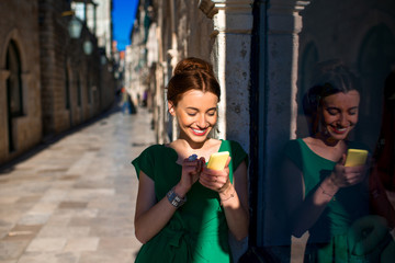 Woman with mobile phone in old city street