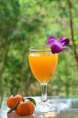 Orange juice in glass, fresh fruits on wooden background