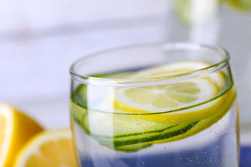 Fresh water with lemon and cucumber in glass, closeup