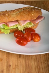 Homemade sandwich with ham in white bread baguette