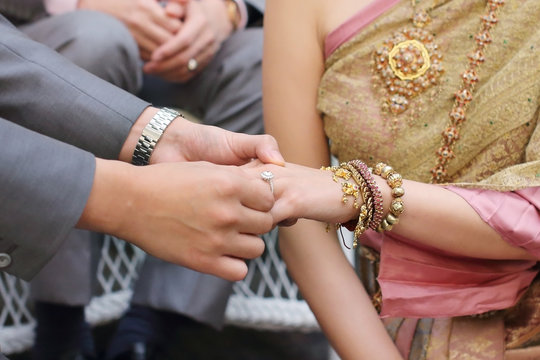 groom put the wedding ring into bride hand