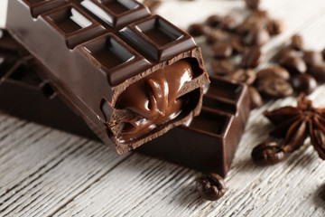 Stuffed chocolate with coffee beans on wooden table, closeup