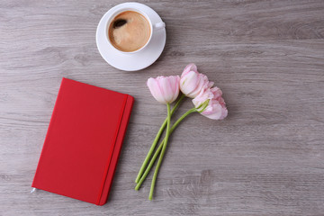 Beautiful tulips with diary and cup of coffee