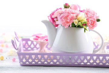 Beautiful spring flowers in teapot isolated on white