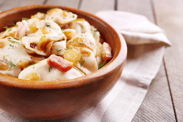 Tasty dumplings with fried onion in brown bowl,