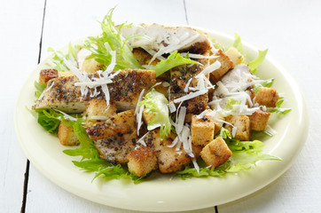 Caesar chicken salad on white table