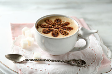 Cup of latte coffee art on wooden table, on light background
