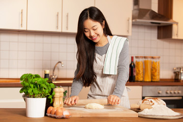 Asian woman is baking bread in her home kitchen