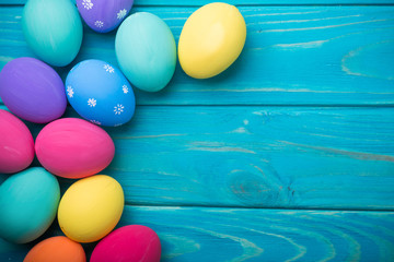 easter colored eggs with lace ribbon on blue wooden background
