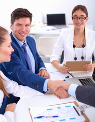 Business people shaking hands, finishing up a meeting, in office