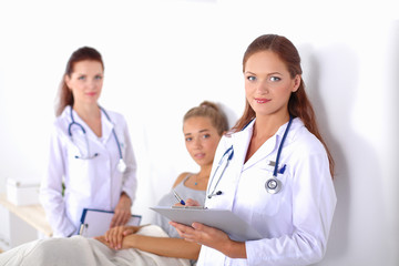 Smiling female doctor with a folder in uniform standing at