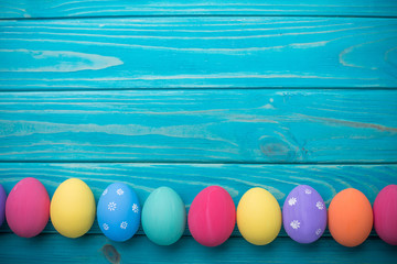 easter colored eggs with lace ribbon on blue wooden background