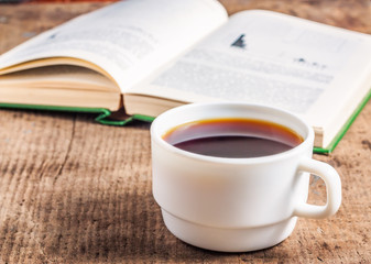 Open book and a cup of coffee on the table