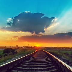 Fototapeta na wymiar railway to horizon in sunset with low clouds