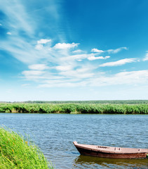 Obraz premium boat on river under cloudy sky
