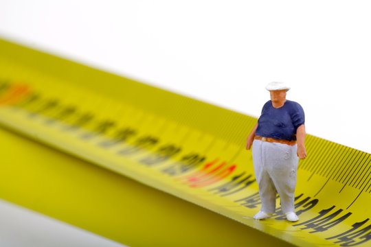 miniatura di uomo obeso e metro