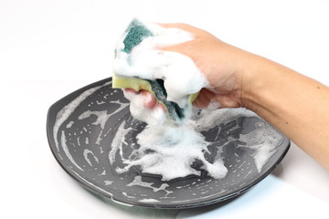 washing dishes with a sponge and dishwashing liquid