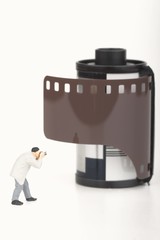 miniatura di fotografo davanti ad un rullino fotografico
