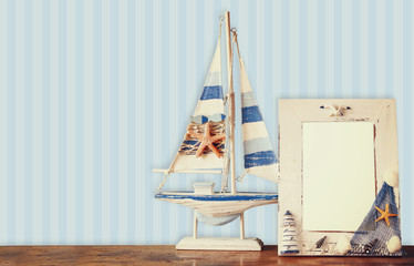 old nautical frame with starfish on wooden table and retro blue 