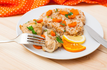 fried chicken with rice in white plate on wooden table
