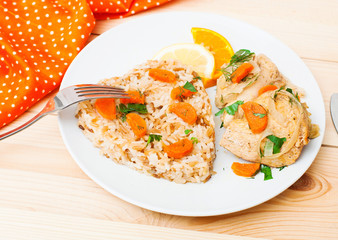 fried chicken with rice in white plate on wooden table