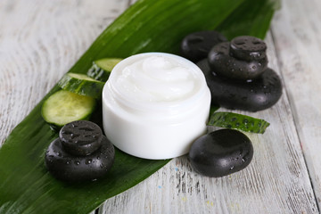 Cosmetic cream with slices of cucumber and spa stones
