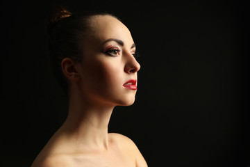 Portrait of beautiful woman with fancy glitter makeup on dark background
