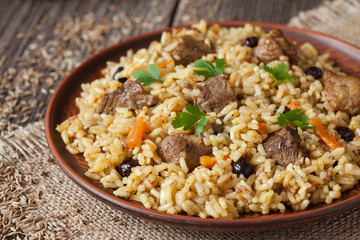 Vintage clay bowl with traditional spicy food called pilaf, on