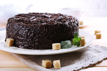 Tasty chocolate cake with cup of tea on table close up