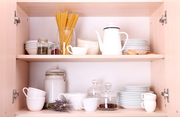 Fototapeta na wymiar Kitchen utensils and tableware on wooden shelves