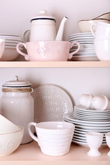 Kitchen utensils and tableware on wooden shelves