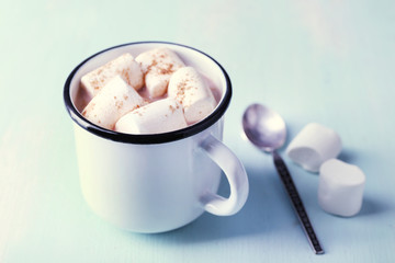 Mug of cocoa with marshmallows on wooden table background