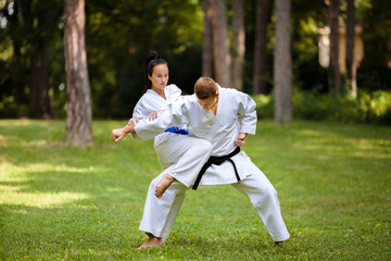 Twee jonge vechtsporters oefenen in de natuur