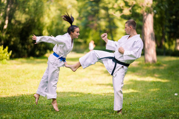 Two young people doing karate in nature