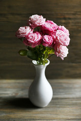 Bouquet of beautiful fresh roses on wooden background