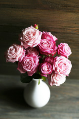 Bouquet of beautiful fresh roses on wooden background